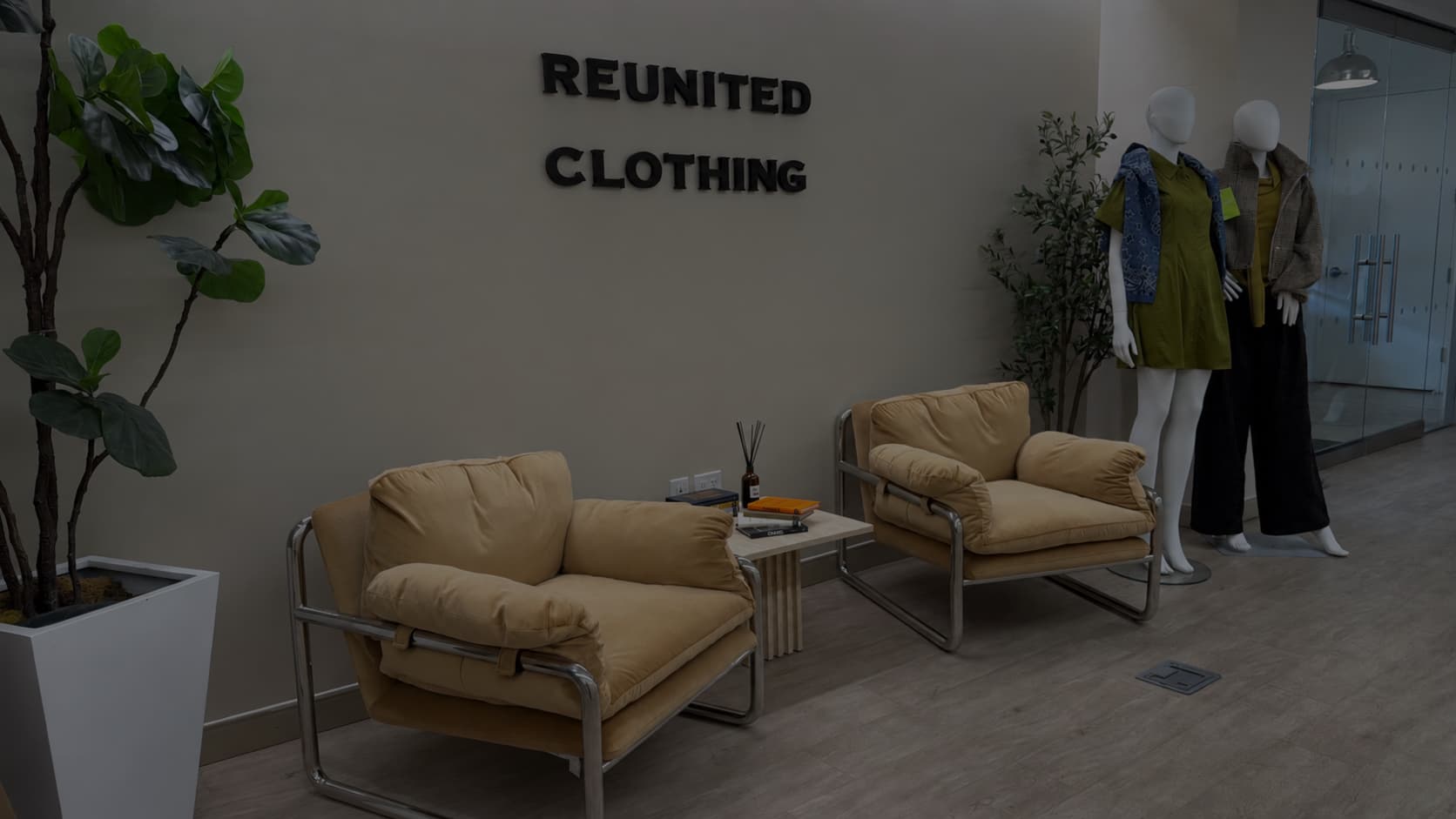 Reunited Clothing office lobby with the company wall sign and dressed mannequins